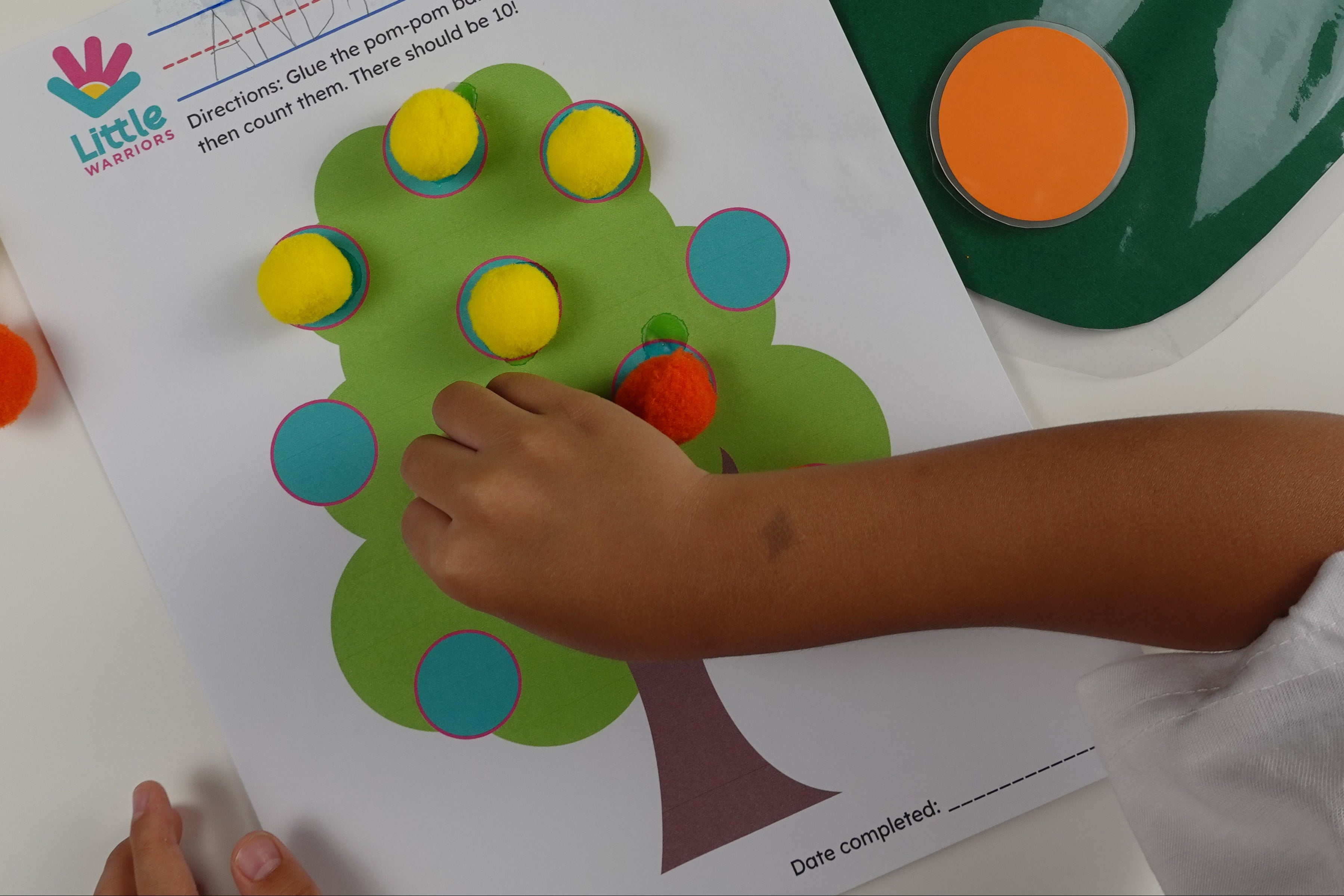 Little Warriors Preschool's Class-in-a-Box Educational Kit, an instructional material designed to teach Christian values, as well as cognitive, socioemotional, and fine & gross motor skills. / Child doing preschool worksheet activities.