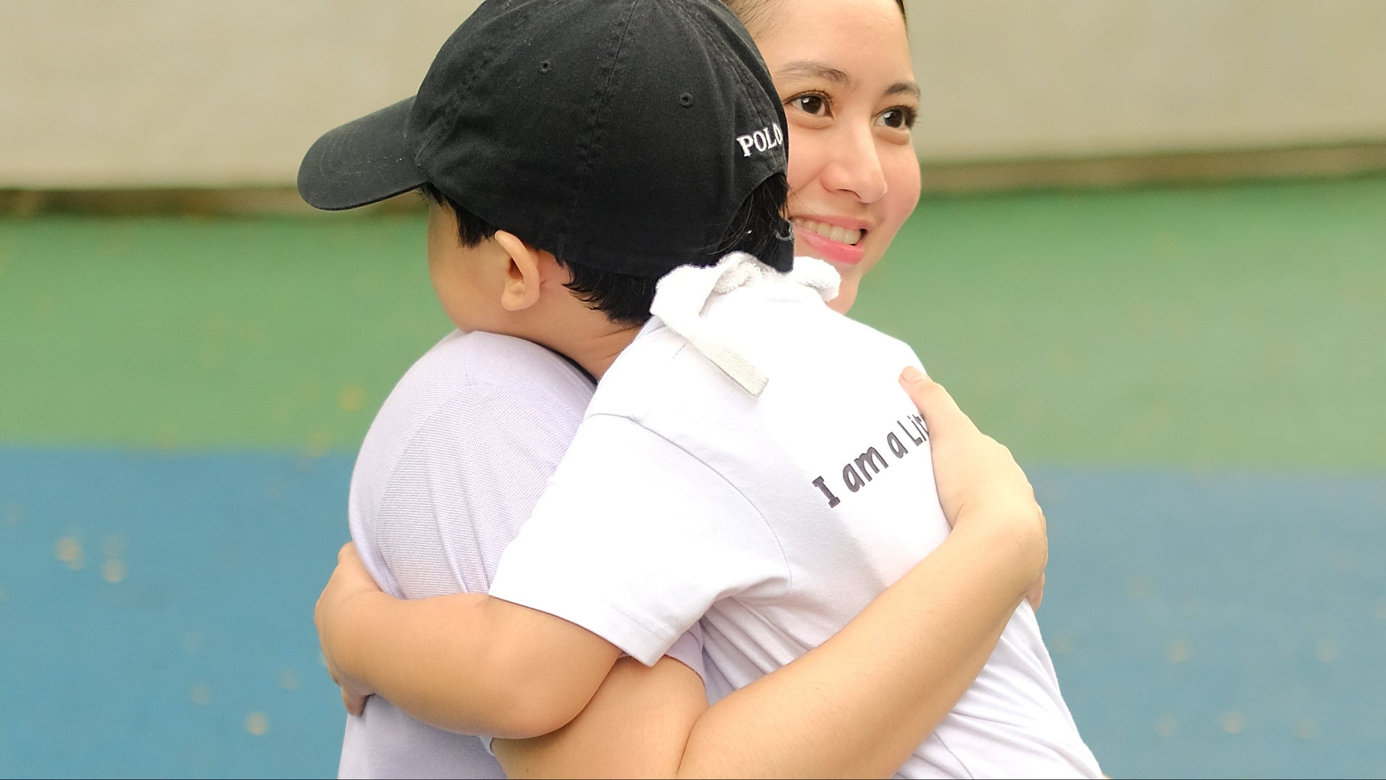 Teacher Miranda "Mimi" Avellana of Little Warriors Preschool embraces a nursery student at Ayala Triangle, Makati City.